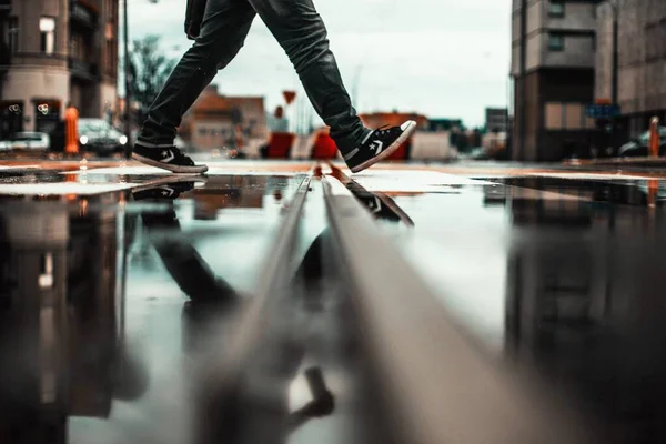 Reflectie van iemands benen op de natte straat in Poznan, Polen — Stockfoto