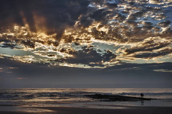 Захватывающий дух снимок отражения облачного неба в океане во время заката — стоковое фото