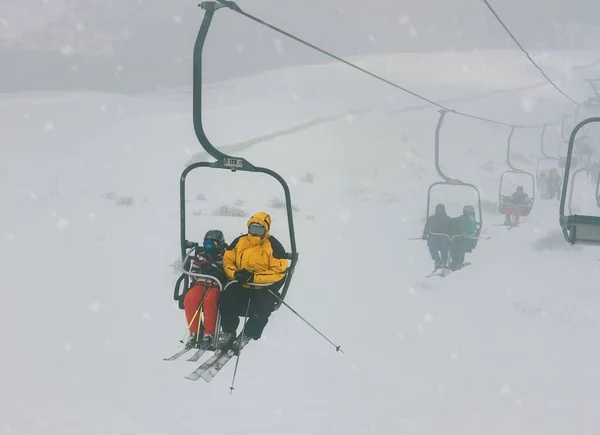 Prachtige foto van mensen die op een touwtje rijden in een besneeuwd gebied — Stockfoto