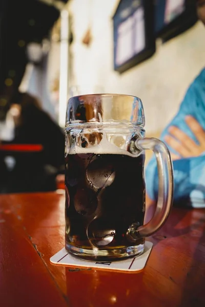パブの木製のテーブルの上にビールのガラスの垂直閉鎖ショット — ストック写真