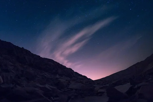 Colina con muchas piezas de metal bajo el hermoso cielo estrellado con aurora — Foto de Stock