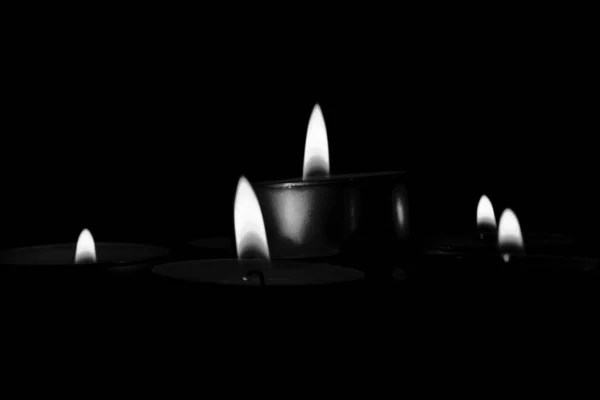 Mysteriöse Graustufenaufnahme von brennenden Kerzen, die eine romantische Atmosphäre schaffen — Stockfoto