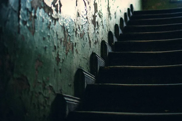 Baixo ângulo tiro das escadas de madeira preta dentro de um edifício abandonado velho — Fotografia de Stock