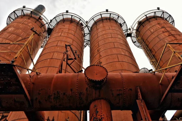 Flachbild von vier Rohren einer Fabrik mit rostigem Geländer — Stockfoto