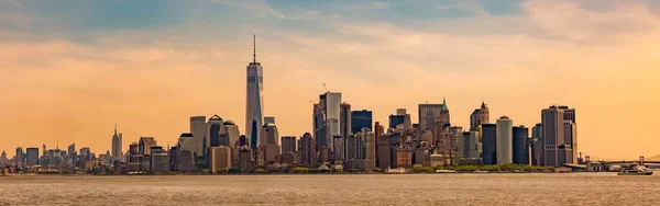 Cidade de Nova York paisagem urbana com arranha-céus altos na margem de um lago sob o céu colorido — Fotografia de Stock