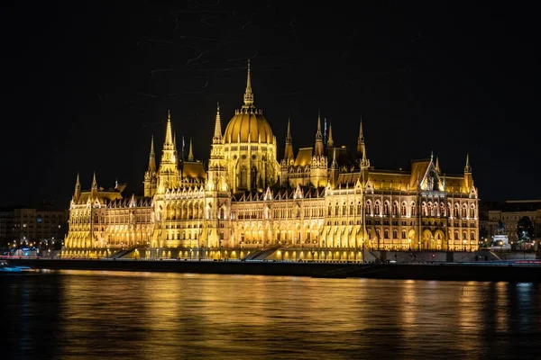 Bela foto do Parlamento húngaro Edifício com luzes à noite refletida no lago — Fotografia de Stock