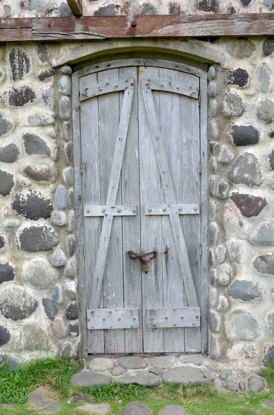 Colpo verticale di una porta di legno su un muro di cemento - grande per uno sfondo fresco — Foto Stock