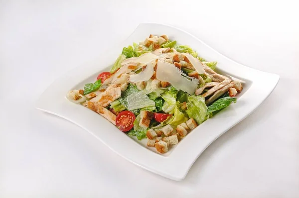 Plan isolé d'une assiette blanche avec salade de Ceasar - parfait pour un blog alimentaire ou une utilisation de menu — Photo