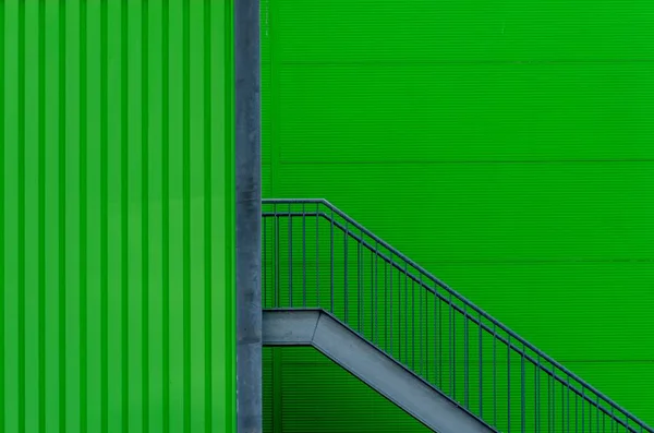 Foto de fondo tonto de una pared verde con escaleras metálicas. —  Fotos de Stock