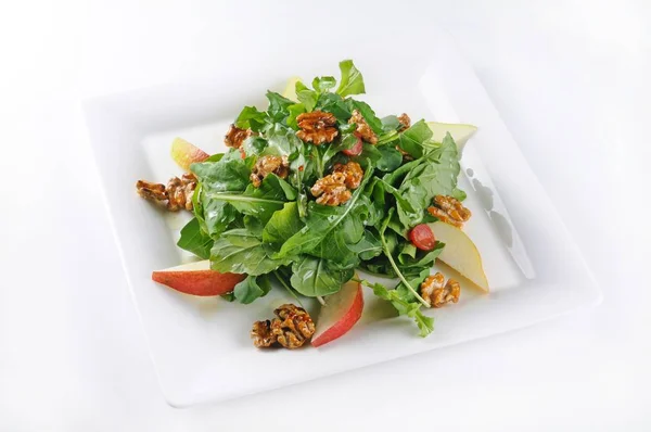 Colpo isolato di un piatto bianco con un'insalata con arugola perfetto per un blog di cucina o un menu di uso — Foto Stock