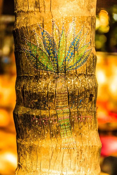 A vertical shot of a palm tree painting on a tree with a blurred background