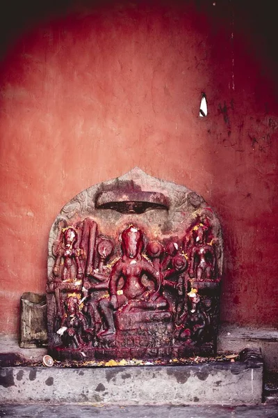 背景に赤い壁で彫刻の垂直クローズアップショット — ストック写真
