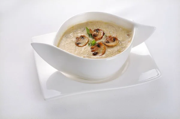 Isolated shot of a white bowl with mushroom soup - perfect for a food blog or menu usage