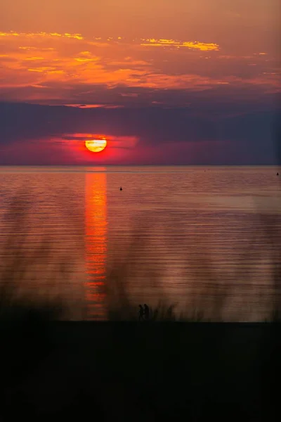Eine Vertikale Aufnahme Des Sonnenuntergangs Über Der Küste Des Ozeans — Stockfoto