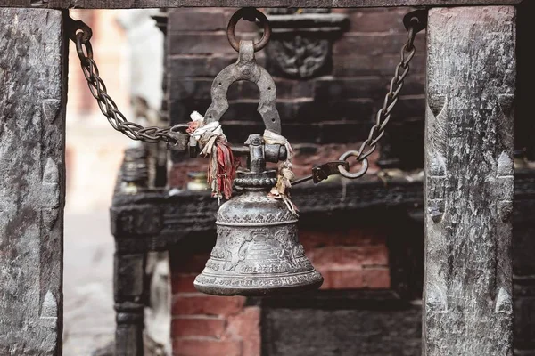 Close-up shot van een bel met beeldhouwen opknoping met een wazige achtergrond — Stockfoto