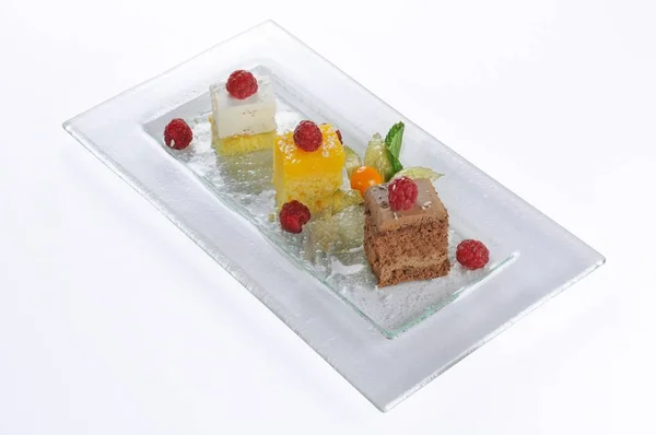 Изолированный снимок тарелки с тремя маленькими тортами для дегустации — стоковое фото