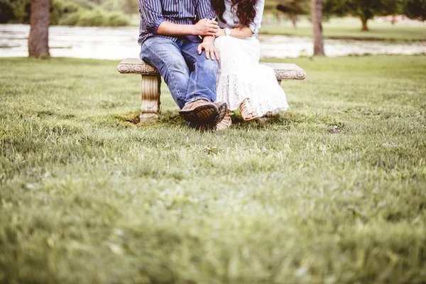 公園で手を取りながらベンチに座っているカップル — ストック写真