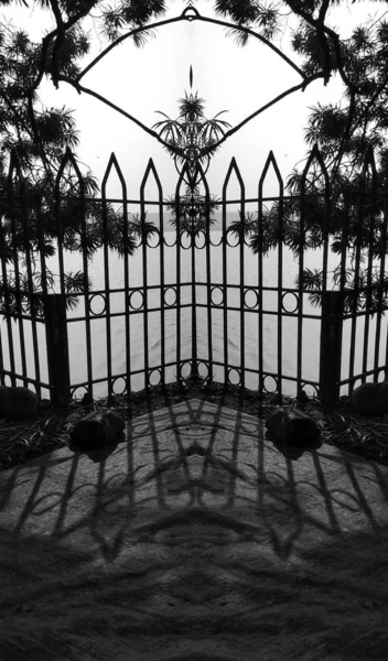 地面に影を反射する門の垂直グレースケールショット — ストック写真