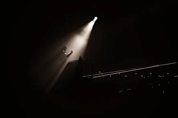 Szary kadr osoby stojącej na scenie w świetle reflektorów — Zdjęcie stockowe