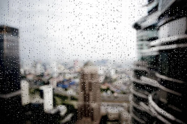 Selektywne Ujęcie Kropli Deszczu Oknie Rozmytymi Budynkami Tle — Zdjęcie stockowe
