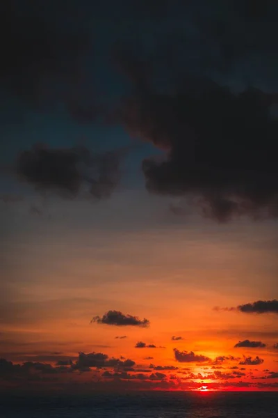 在巴厘岛 一张垂直拍摄的海洋照片 太阳在云层后面落下 — 图库照片