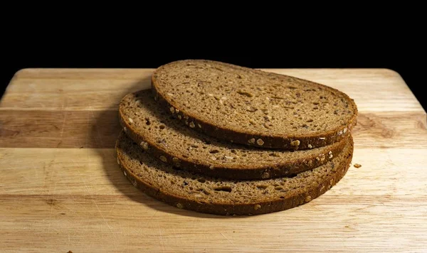 Closeup Shot Slices Rye Bread Wooden Chopping Board Black Background — Stock Photo, Image