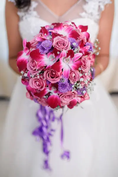 Вертикальний знімок нареченої, що тримає весільний букет з рожевими трояндами — стокове фото