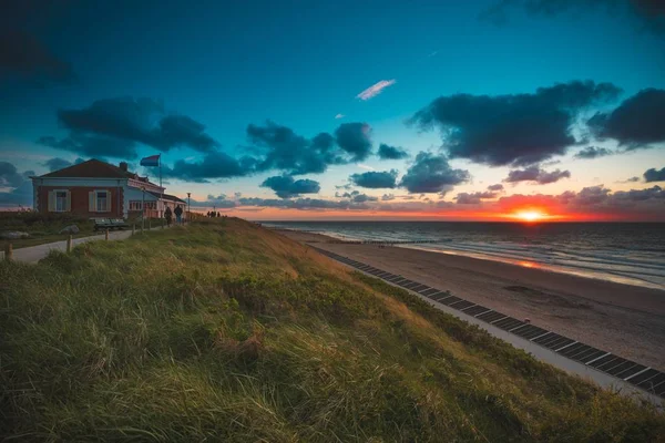 Huis op het gras overdekte strand aan de oceaan onder de prachtige hemel in Domburg, Nederland — Stockfoto