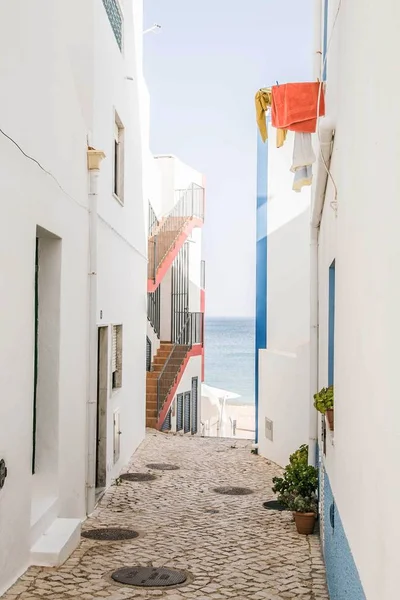 Tiro vertical de um beco entre edifícios brancos que levam à praia — Fotografia de Stock