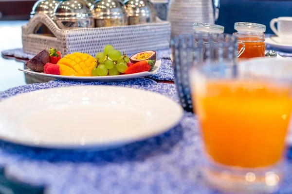 Primer plano de una mesa de desayuno con frutas y jugo con vajilla elegante — Foto de Stock