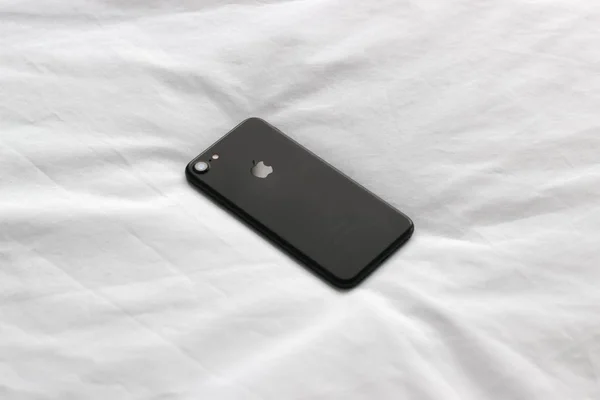WOLVERHAMPTON, UNITED KINGDOM - Jul 24, 2017: A high angle shot of an iPhone in a black case on a white blanket