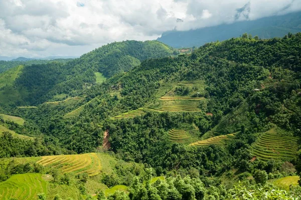 Foto de ángulo alto de un hermoso paisaje verde con altas montañas bajo el cielo nublado en Vietnam — Foto de Stock