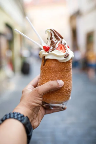 Vertical shot of a person holding a cronut ice-cream in Prague, Czech Republic — Stock Photo, Image