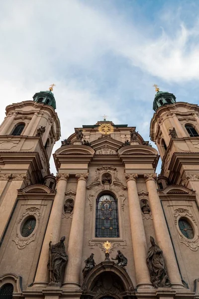 Vertikální nízkoúhlý snímek kostela sv. Mikuláše pod zataženou oblohou v Praze — Stock fotografie