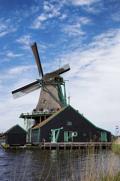 Niederwinkelaufnahme von Windmühlen in der Nachbarschaft von Zaanse Schans in der Nähe des Sees in den Niederlanden — Stockfoto