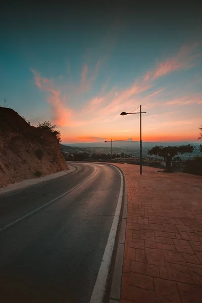 Tiro vertical de uma estrada com o céu colorido no fundo capturado na Andaluzia, Espanha — Fotografia de Stock