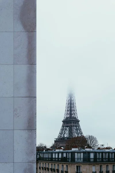 Tiro vertical da parte inferior da famosa torre Eiffel com o topo coberto com nevoeiro — Fotografia de Stock
