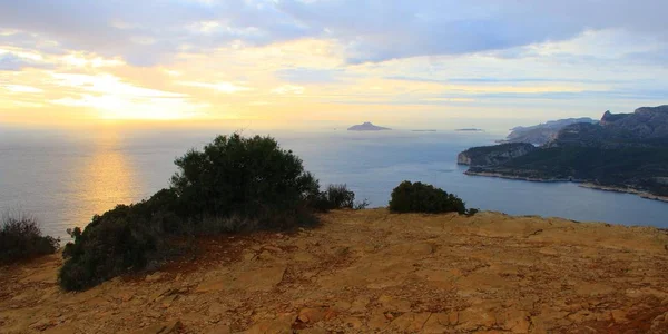 Uma baía cercada por formações rochosas com a bela vista do nascer do sol no fundo — Fotografia de Stock