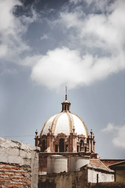 Függőleges felvétel egy régi katolikus templomról, felhős égbolttal a háttérben Mexikóban — Stock Fotó