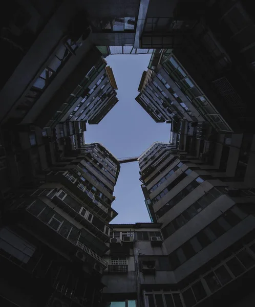 Bajo ángulo de tiro de edificios de apartamentos altos bajo el cielo oscuro — Foto de Stock