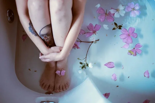 Tatuado menina sentado banheira com flores — Fotografia de Stock