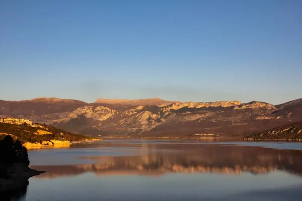 Широкий Снимок Отражения Гор Озере Ясным Голубым Небом — стоковое фото