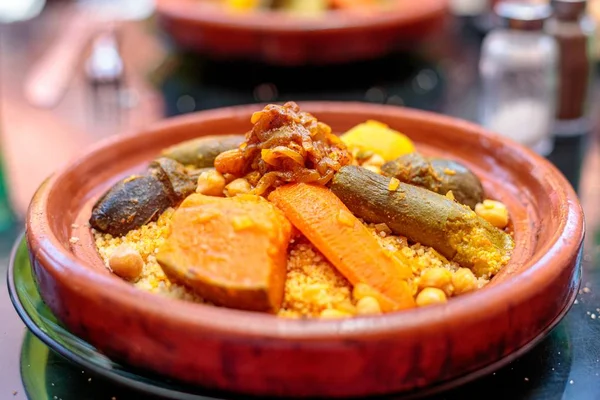A high angle closeup shot of couscous in a clay plate on blurred background — Stock Image High Angle Closeup Shot Couscous Clay Plate Blurred Background Stock Image