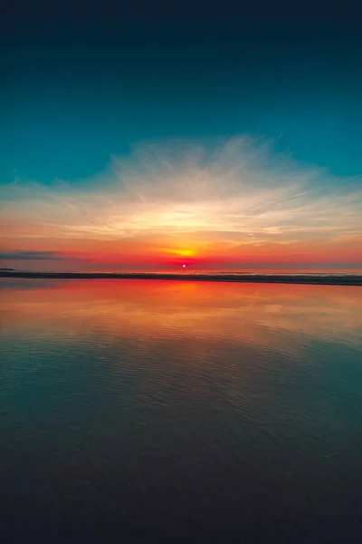 荷兰Vrouwenpolder拍摄的海滩日落倒影的垂直镜头 — 图库照片