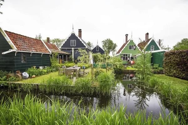 Bereik van schattige kleine huizen in de buurt van het meer, omringd door groene planten — Stockfoto