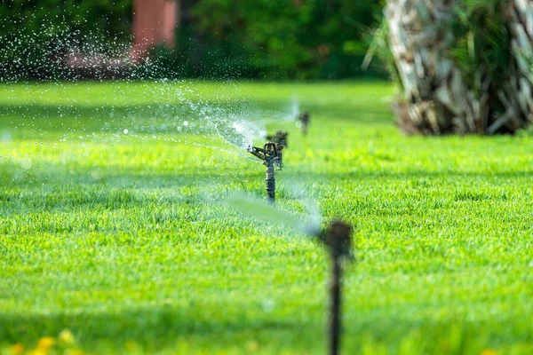 Gros plan des arroseurs de pelouse avec les gouttes d'eau dans l'air — Photo