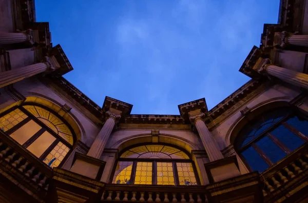Hermosa toma de ángulo bajo de un edificio con ventanas en forma de arco tocando el cielo —  Fotos de Stock