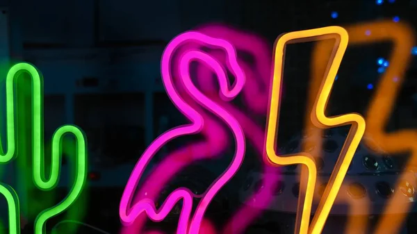 Closeup shot of colorful glowing neon light characters on glass — Stock Photo, Image