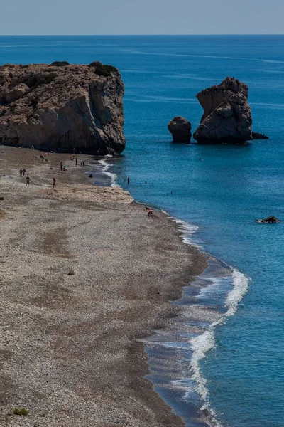 A vertical shot of the calm ocean waves moving towards the shore in Cyprus