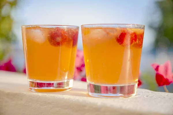 Nahaufnahme zweier orangefarbener Caipi-Cocktails mit verschwommenem Hintergrund — Stockfoto